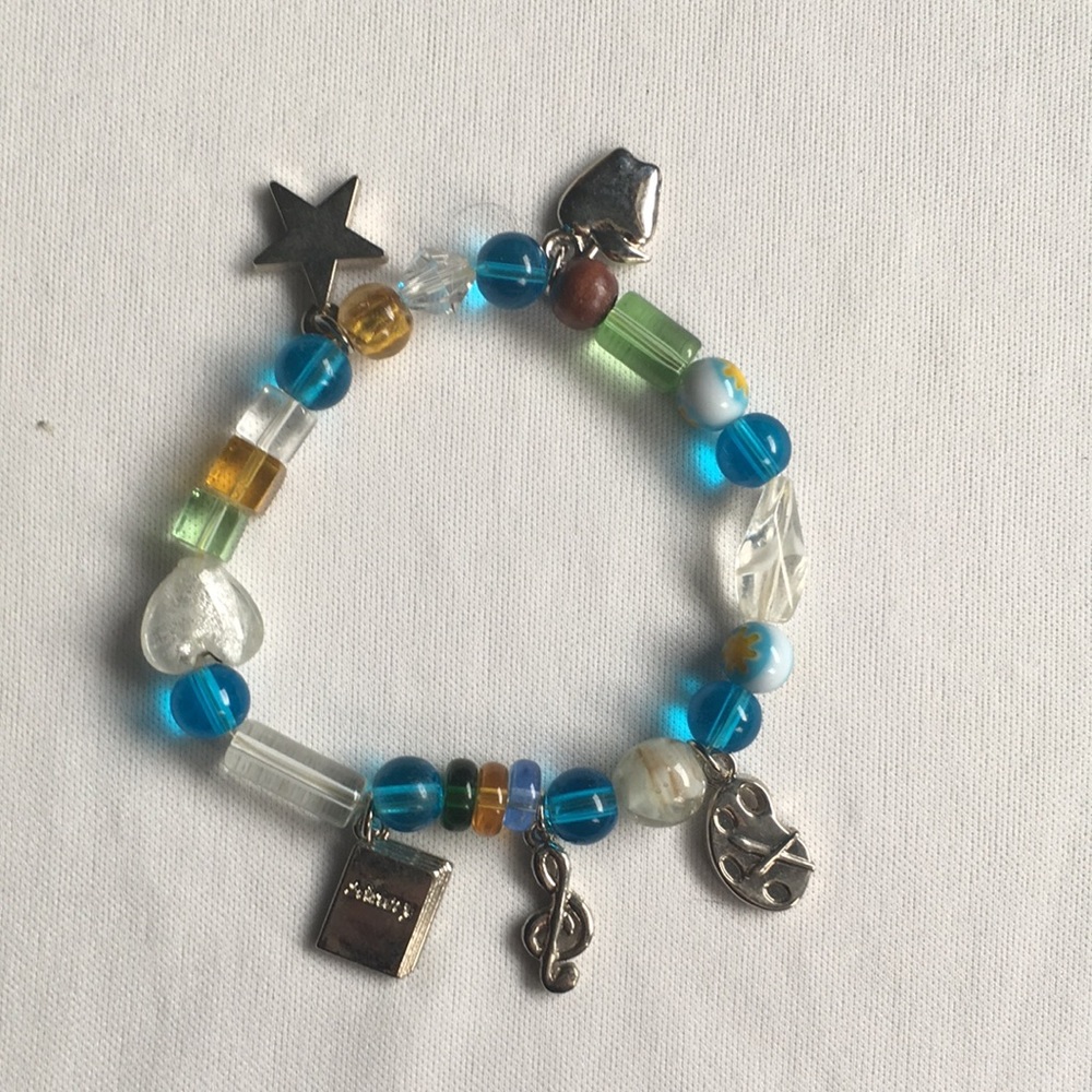 Beaded racelet with silver toned charms. S…